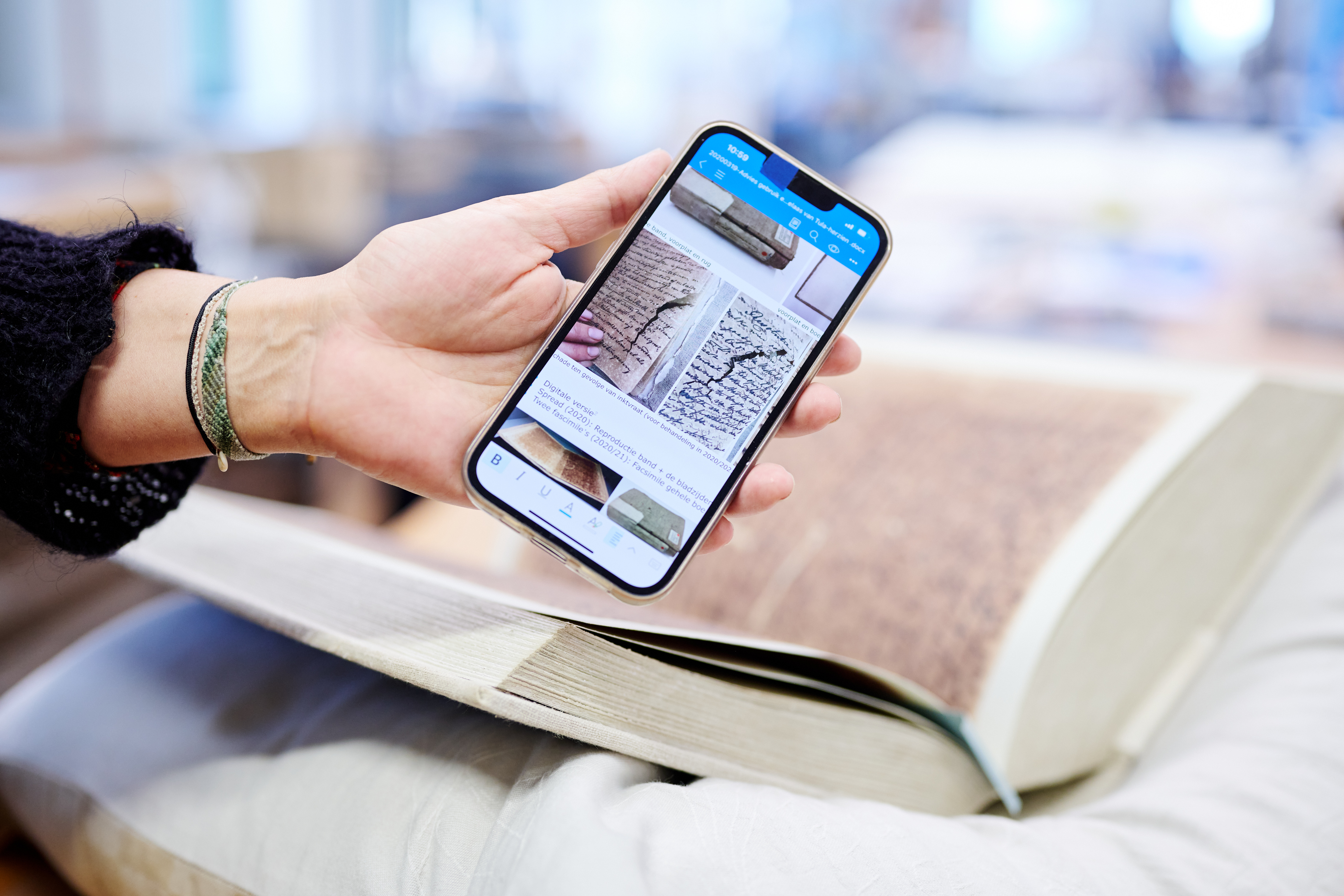 Een kopie van het boek op een kussen en op de mobiele telefoon is het originele boek met het relaas te zien Fotograaf: Erik Jansen Een kopie van het boek op een kussen en op de mobiele telefoon is het originele boek met het relaas te zien Fotograaf: Erik Jansen