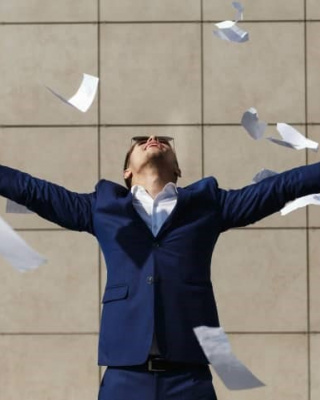 Afbeelding van man in pak met papier om zich heen.