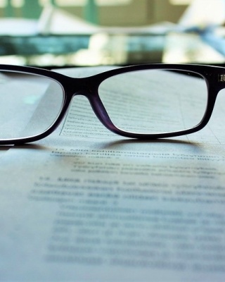 Foto van een bril op papier met getypte tekst.
