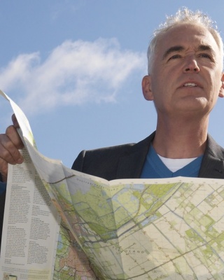 Foto van Tineke Dijkstra met twee mensen met een wegenkaart in de hand. 