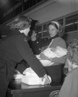 Aankomst KLM-vliegtuig "Maastricht" op Schiphol met Indonesische evacués uit Singapore. Achter de balie mevr. L. van Overeem van het Rode Kruis. Foto Eric Koch / Anefo