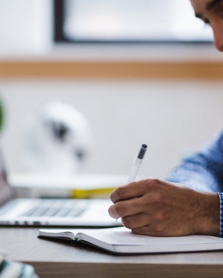Foto van man aan het werk achter zijn computer.