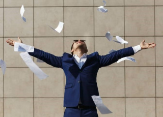 Afbeelding van man in pak met papier om zich heen.