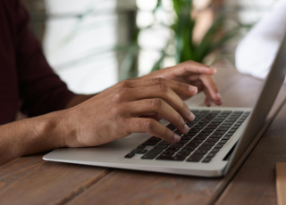 Afbeelding van iemand achter de computer.