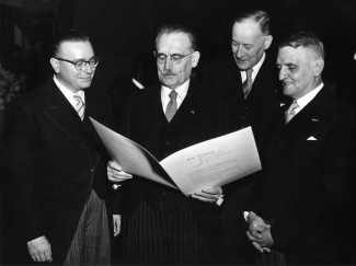 Premier Jonckheer (Nederlandse Antillen), premier Drees (Nederland), minister Kernkamp (Nederlandse Minister van Overzeese Rijksdelen) en premier Currie (Suriname) bekijken het Statuut na de ondertekening (1954)