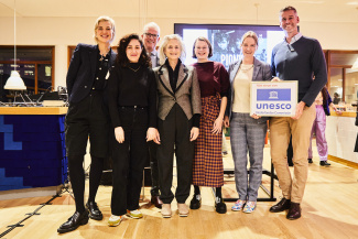 Marielies Schelhaas overhandigt het Unesco patronage aan directeur Tom De Smet.