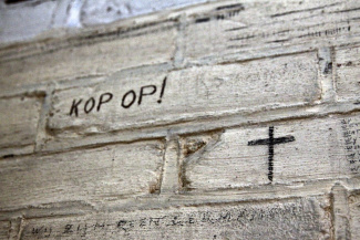 Inscriptie muur dodencel Oranjehotel