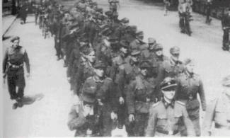Landstorm soldaten marcheren onder canadese bewaking naar de Harskamp, mei 1945